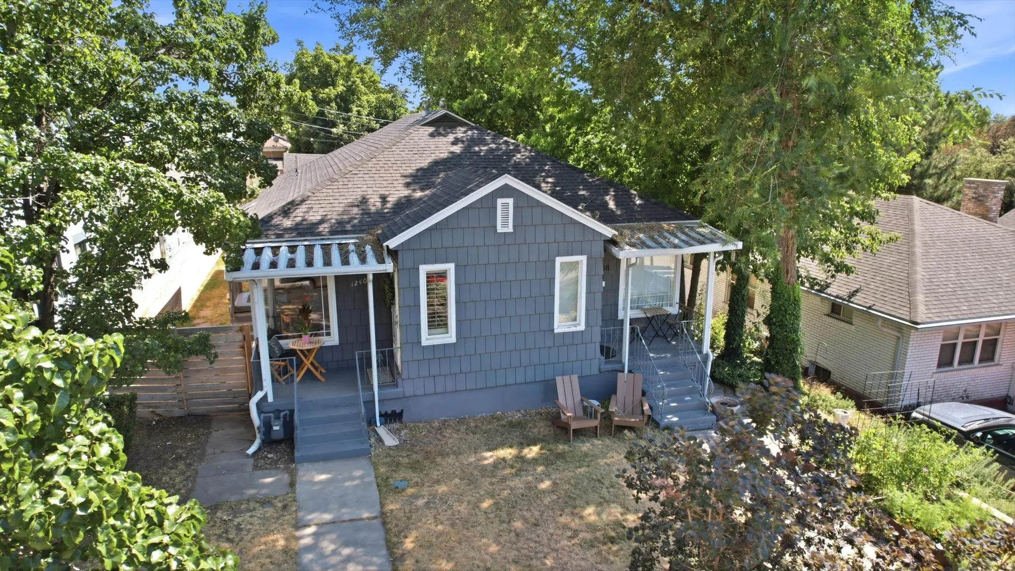 Craftsman-style home featuring shingled siding, a covered porch with a railing, a second covered porch with open sides, and a paved walkway
