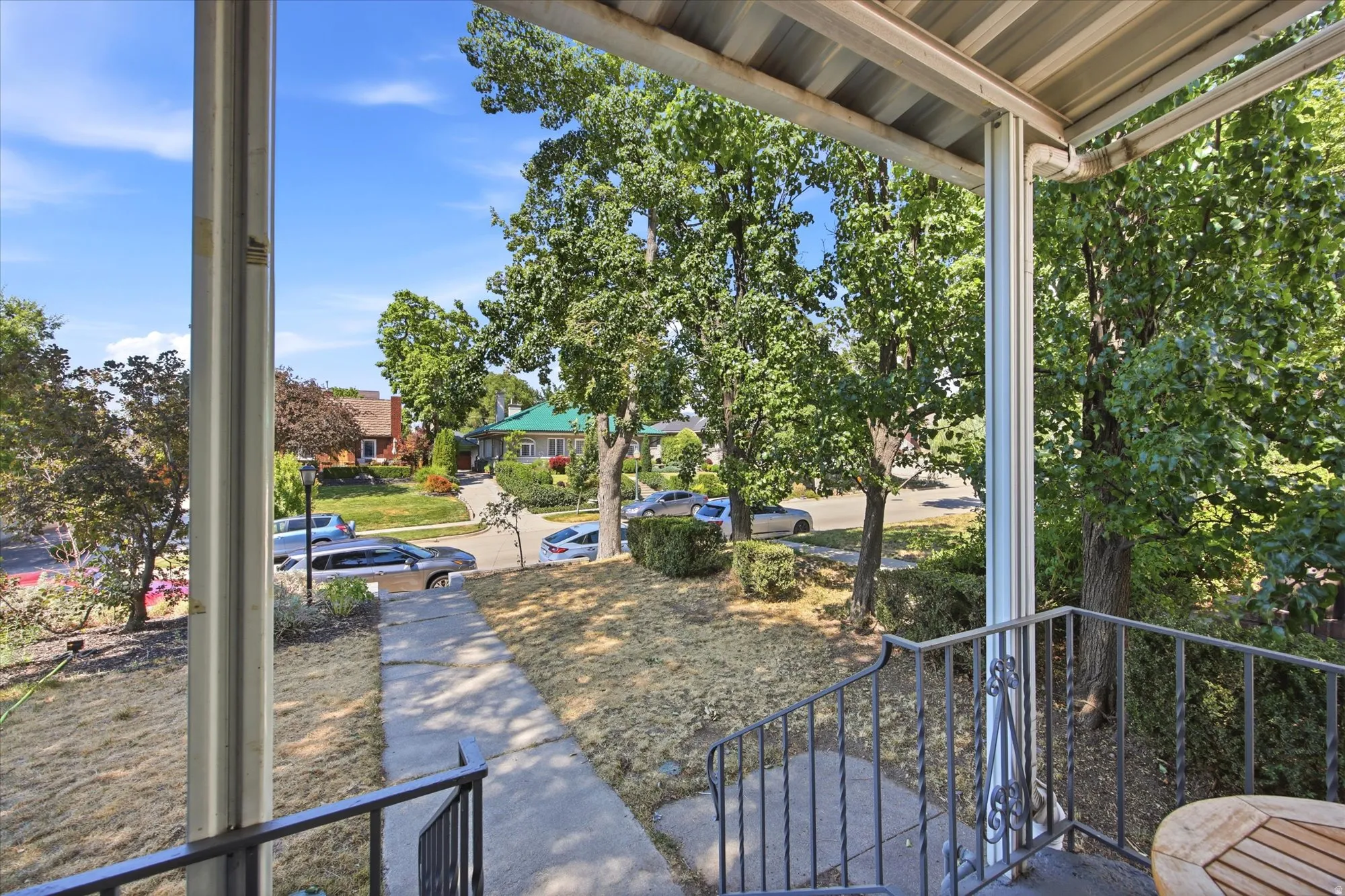Covered front porch with metal corrugated ceiling and white support columns