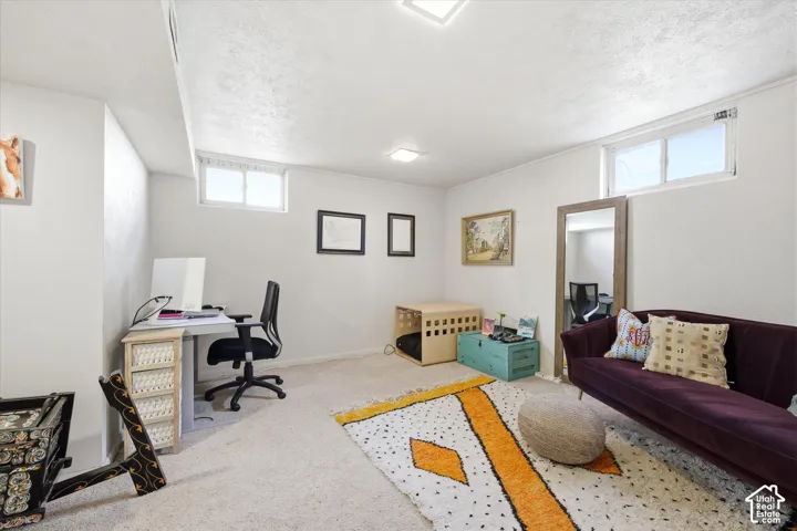 Spacious carpeted room featuring white walls, two transom windows, and recessed lighting