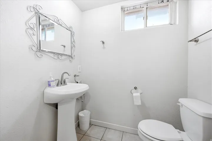 Bathroom featuring a pedestal sink, chrome-finish faucet, and a window providing natural light
