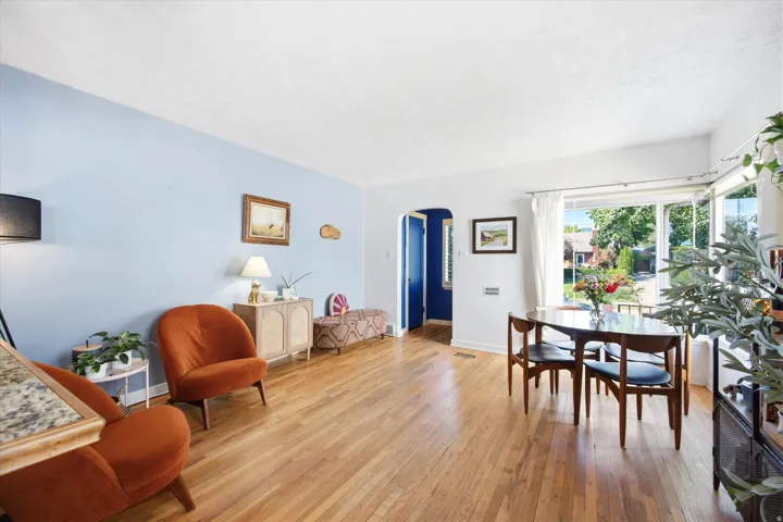 Hardwood flooring spans this room featuring a light blue accent wall and large windows