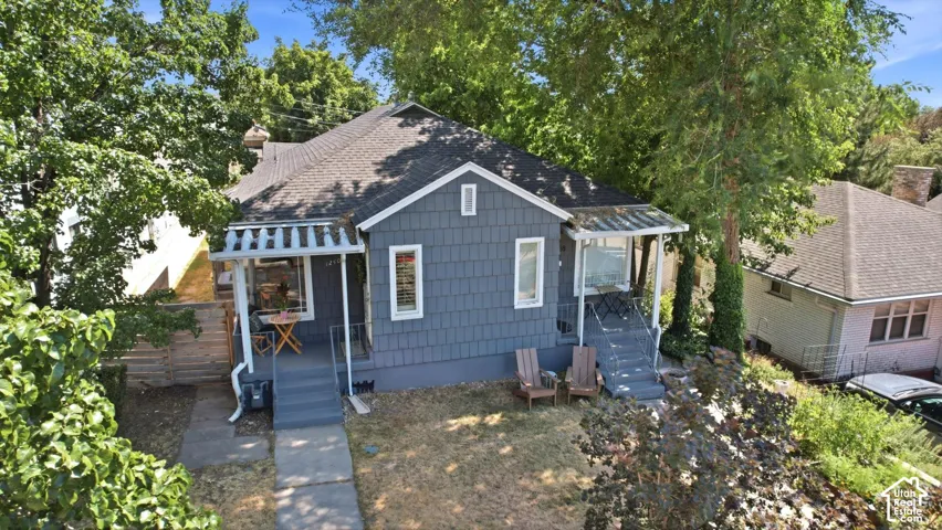 Craftsman-style home featuring shingled siding, a covered porch with a railing, a second covered porch with open sides, and a paved walkway