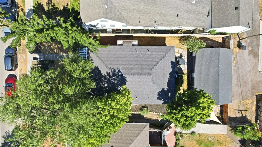 Main property featuring a grey shingle roof, accompanied by a detached structure with a matching grey shingle roof
