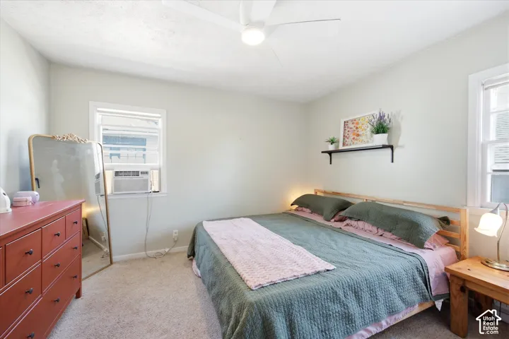 Carpeted room with light-colored walls and a ceiling fan