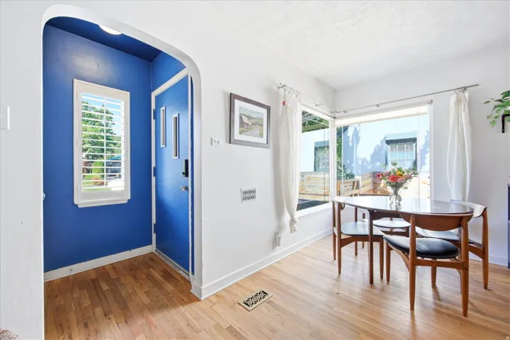 Hardwood-finish flooring extends through an arched entryway into an open area with corner windows