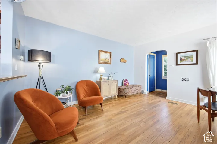 Hardwood flooring throughout a living space featuring light blue and white painted walls