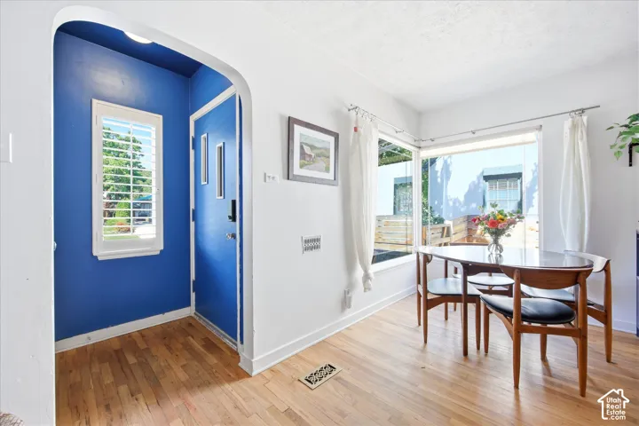 Hardwood-finish flooring extends through an arched entryway into an open area with corner windows