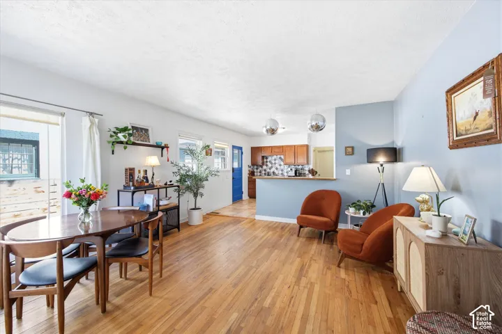 Open-concept living area featuring wood-finish flooring, white walls, and a light blue accent wall