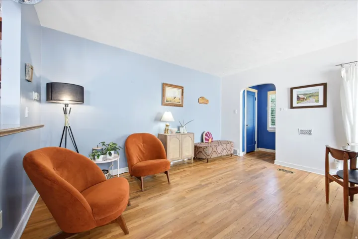 Hardwood flooring throughout a living space featuring light blue and white painted walls