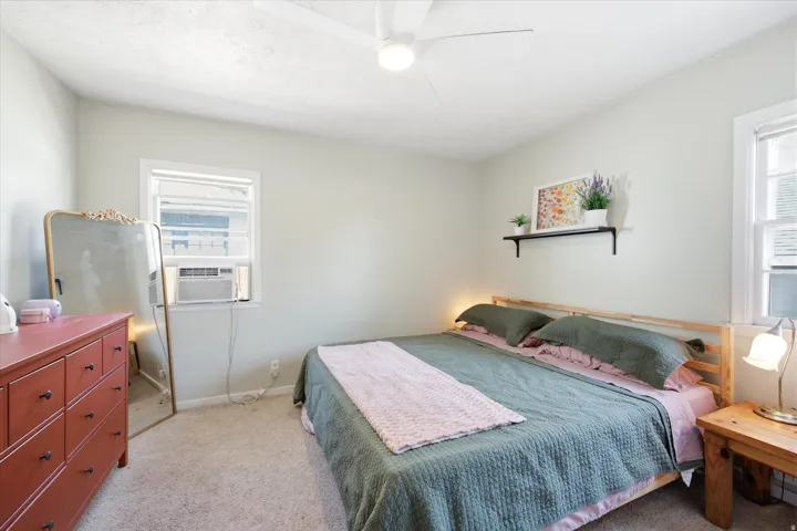 Carpeted room with light-colored walls and a ceiling fan