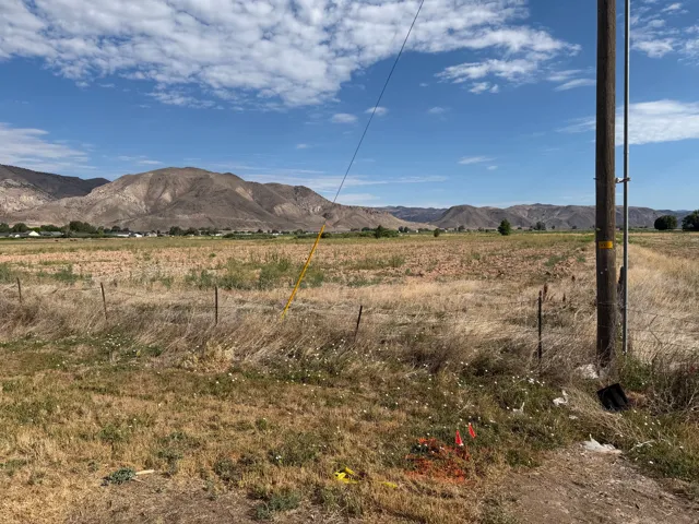 Expansive undeveloped land featuring a partial wire fence and distant mountain range