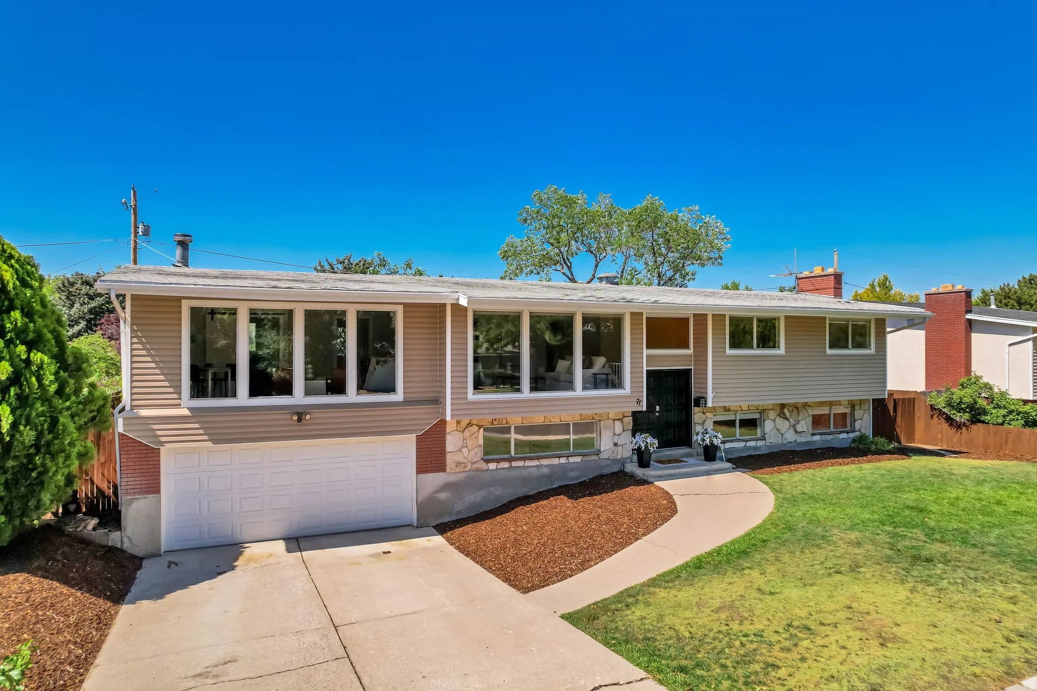 Split-level residence featuring a two-car garage with a concrete driveway