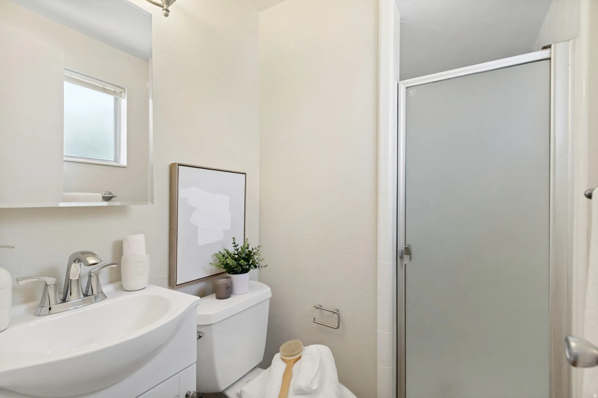 Primary Bathroom featuring a vanity with a white basin sink, chrome faucet, and mirrored medicine cabinet