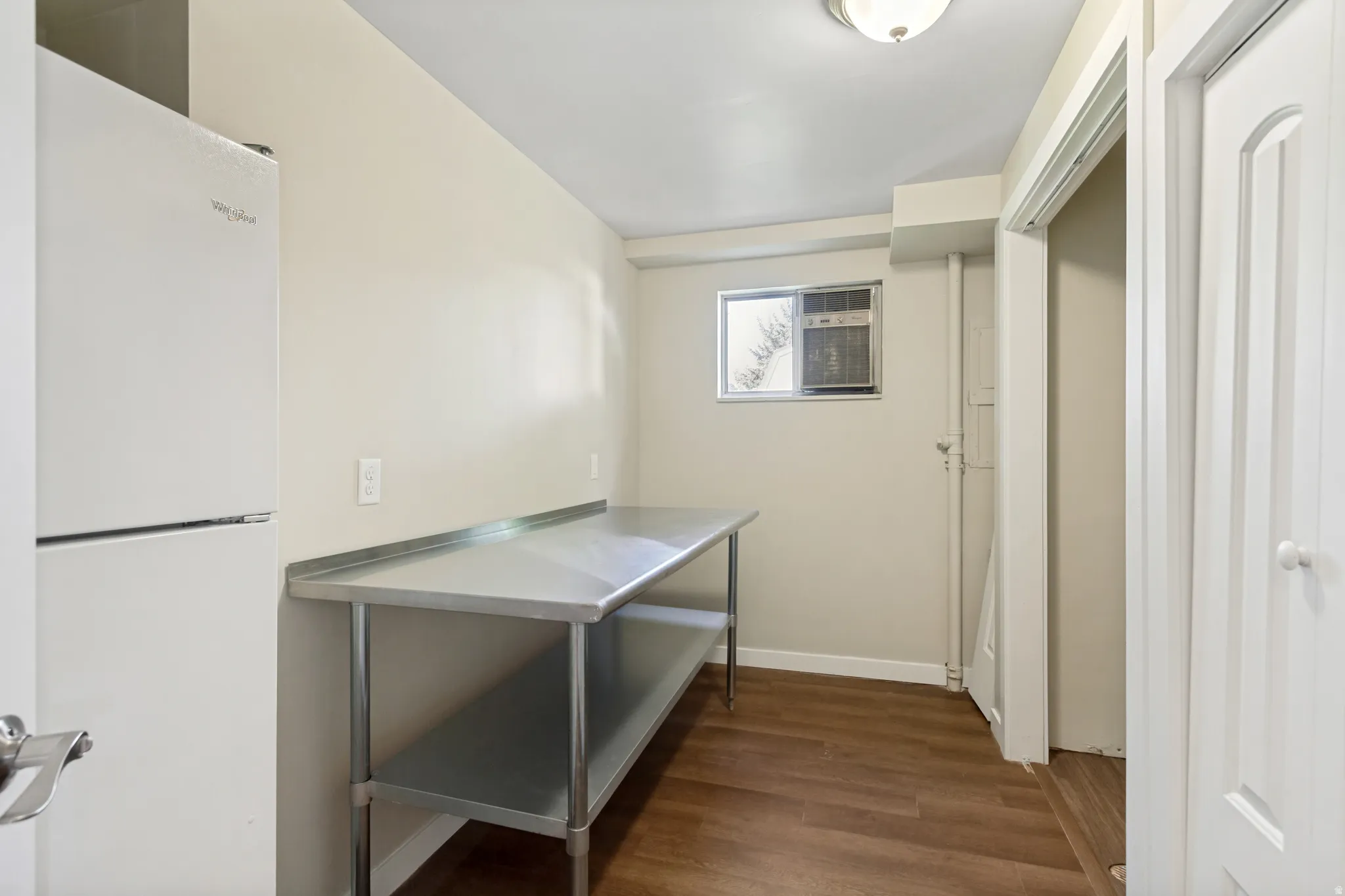 Neutral wall paint, wood-finish flooring, and a stainless steel prep table
