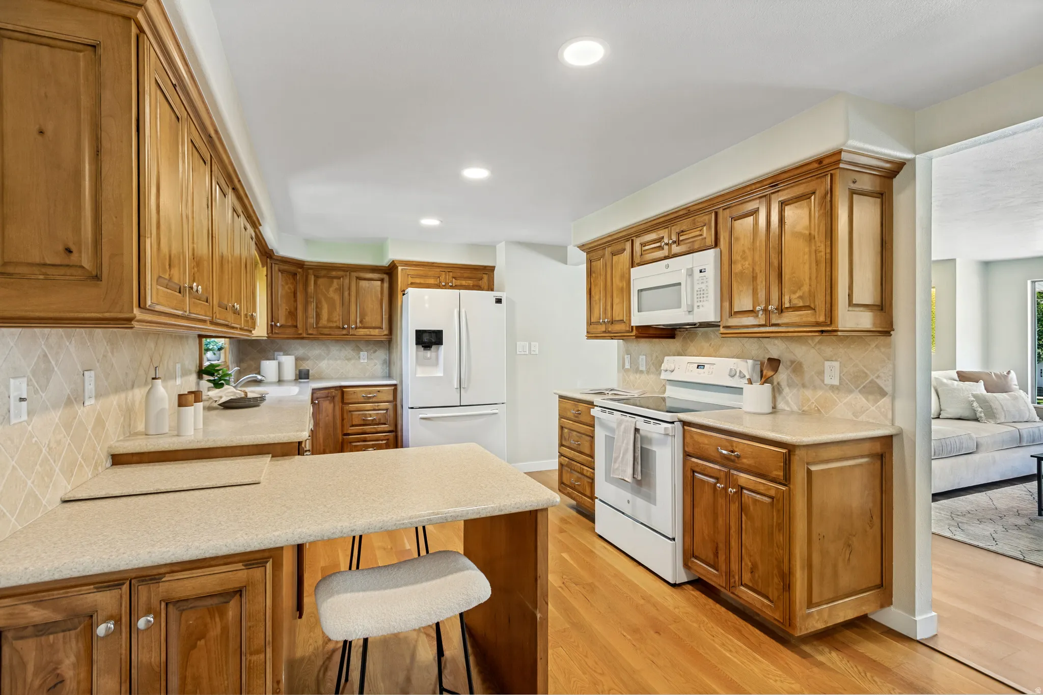 Kitchen featuring wood-finish cabinetry, light countertops, and a tiled backsplash