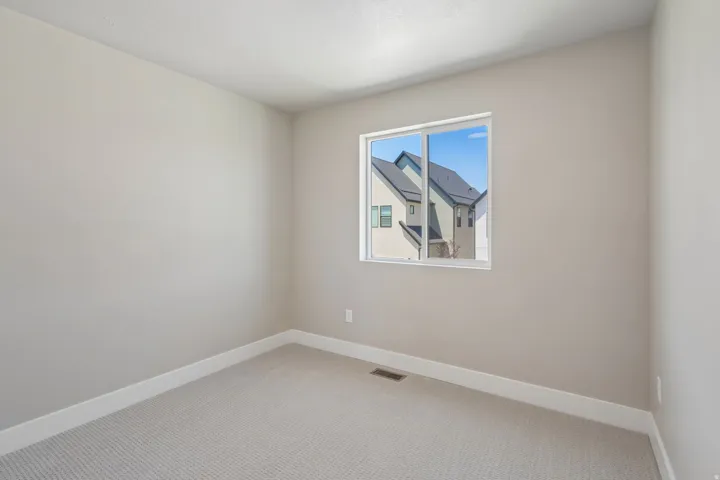 Neutral-toned wall finish with white trim and light patterned carpet