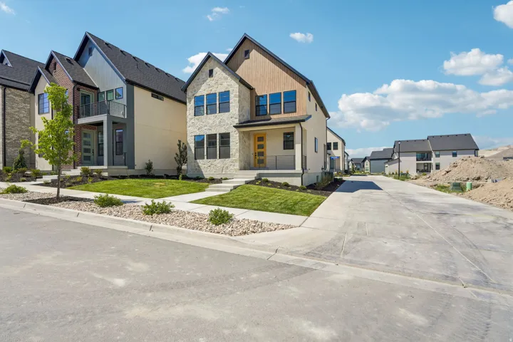 Contemporary architecture featuring a stone and wood-panel facade, an inviting front porch, and a professionally landscaped front yard with mature plantings