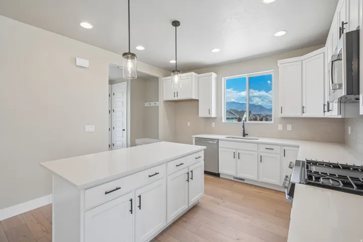 Contemporary kitchen featuring a large central island with white cabinetry and a solid surface countertop