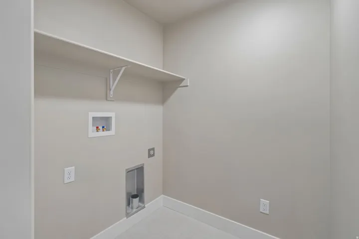 Dedicated laundry area featuring a wall-mounted shelf, washer hookups, and dryer vent