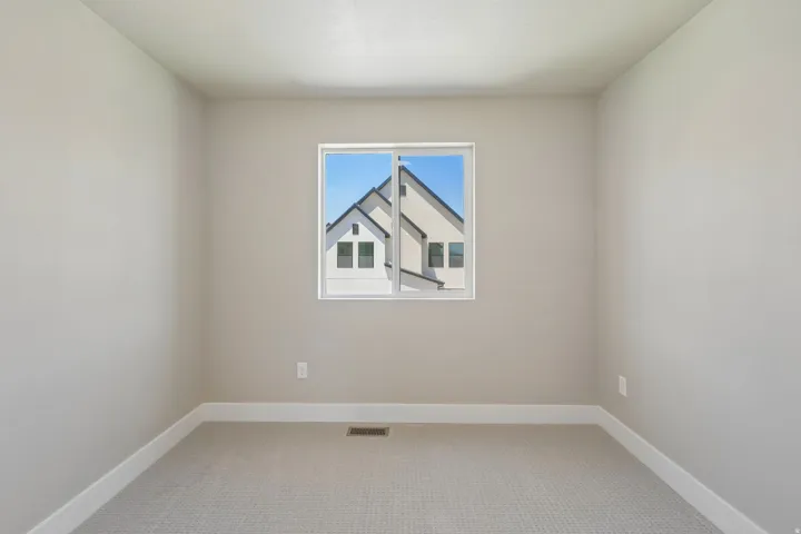 Neutral-toned walls complement the light-colored carpet flooring