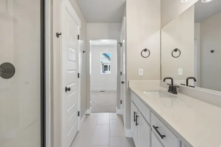 Contemporary bathroom featuring a spacious vanity with an integrated sink, matte black faucet, and a large mirror