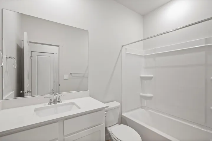 Contemporary bathroom with a single vanity, integrated sink, chrome faucet, and expansive wall-mounted mirror