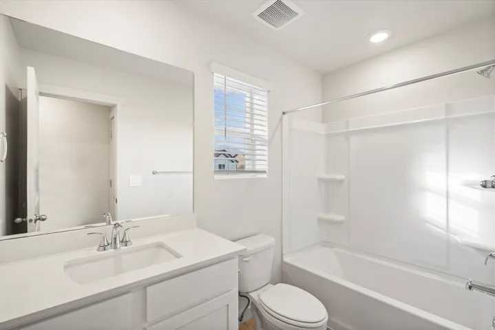 Bathroom featuring a white vanity with an integrated sink, polished chrome faucet, and a large wall-mounted mirror