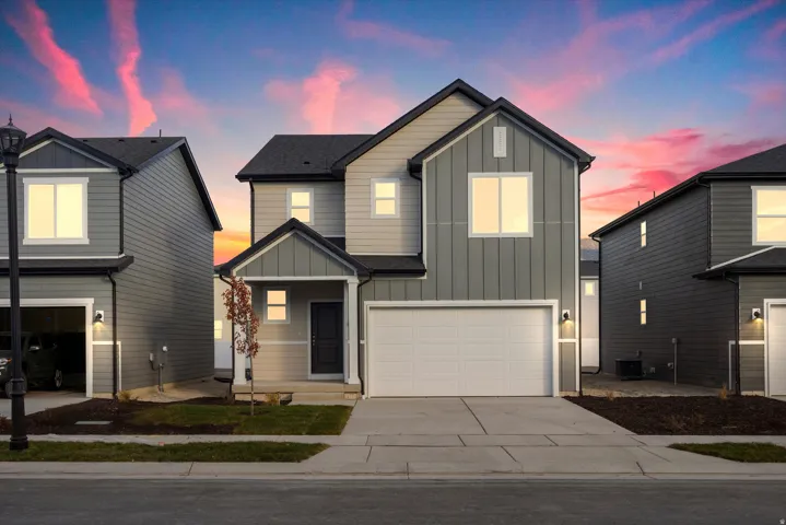 Contemporary two-story residence featuring a dark gray roof, light gray siding, and board and batten accents