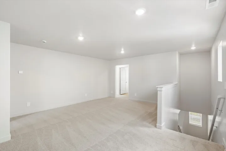 Spacious carpeted room featuring recessed lighting, white walls, and white trim