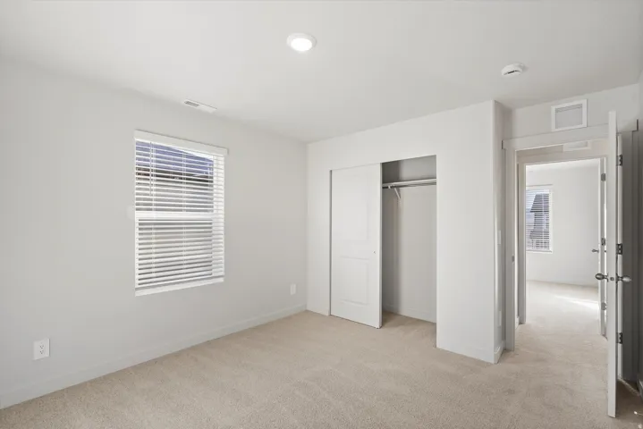 Bedroom featuring neutral paint, carpeted flooring, a window with blinds, recessed lighting, and a bi-fold closet