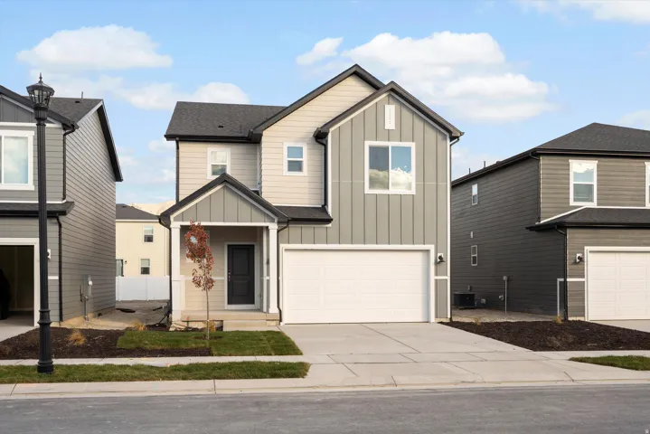 Contemporary two-story residence featuring a covered entry, an attached two-car garage, and a combination of horizontal and vertical siding