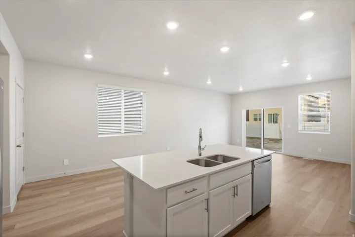 Modern kitchen island featuring a double-basin stainless steel sink, contemporary faucet, and integrated dishwasher