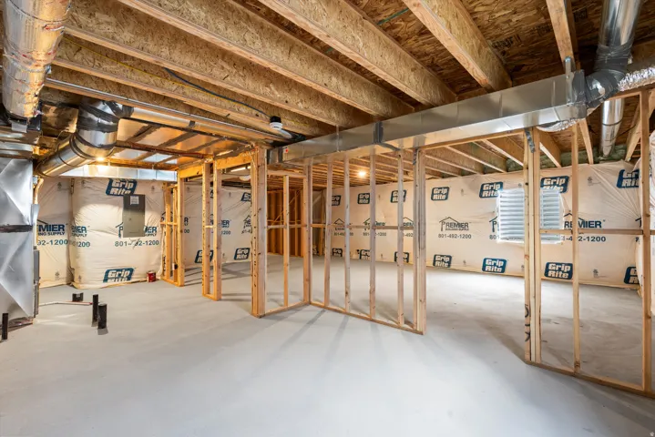 Unfinished basement with concrete flooring and exposed ceiling joists