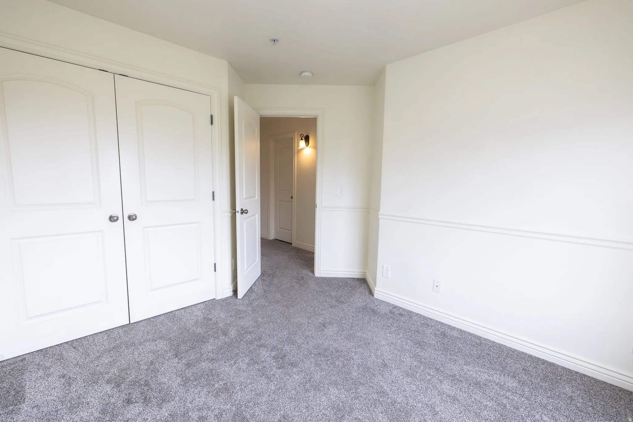 Room featuring neutral carpeting, white walls, and white baseboards