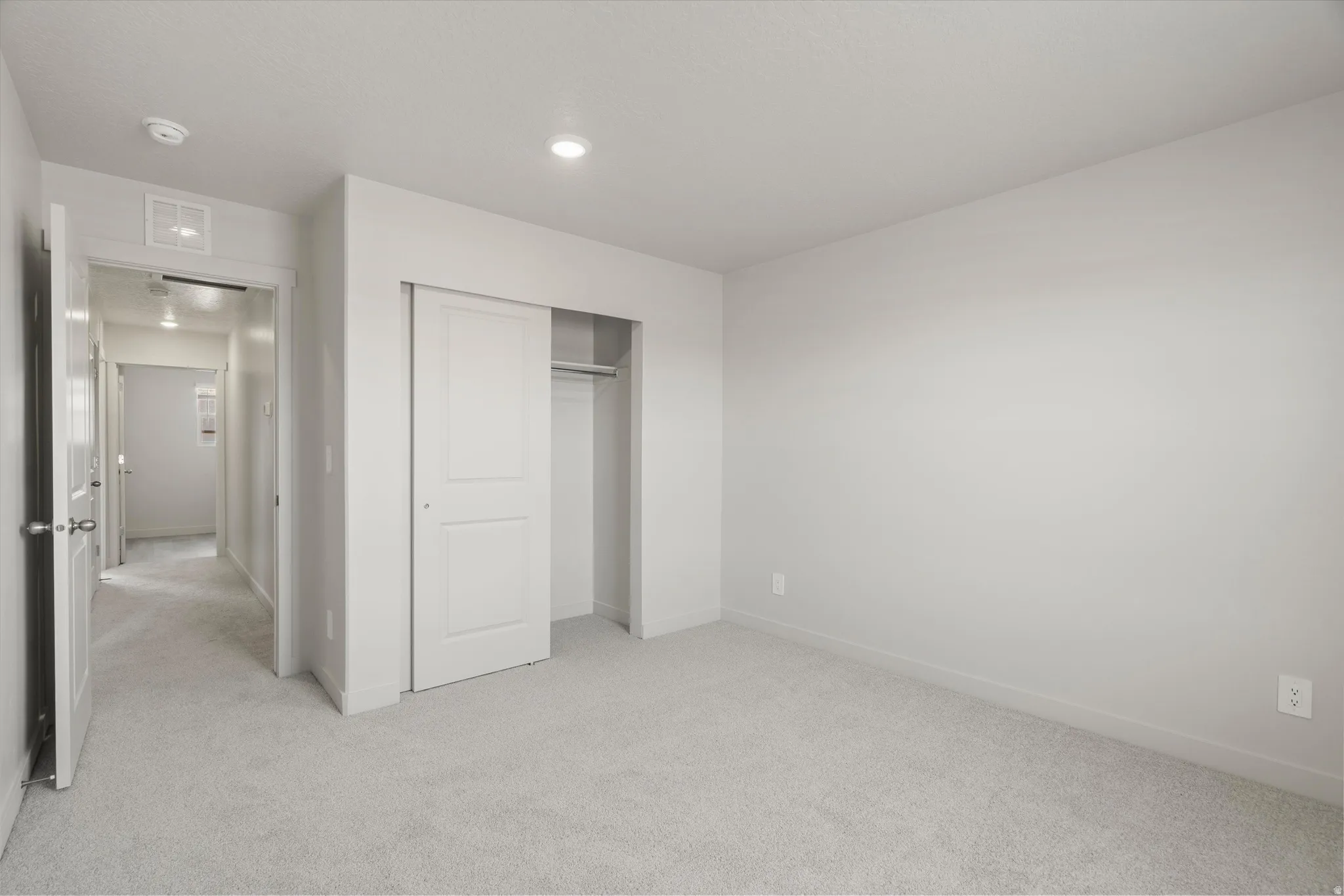 Wall-to-wall carpeting in a neutral tone, complemented by light-colored walls