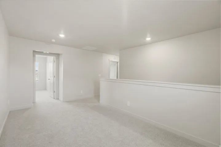 Spacious carpeted landing featuring recessed lighting and neutral wall finishes