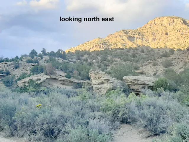 Expansive natural landscape featuring rugged mountainous terrain with visible rock formations and indigenous foliage