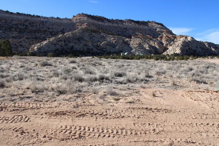Expansive land parcel featuring natural desert vegetation and direct access to a prominent hillside
