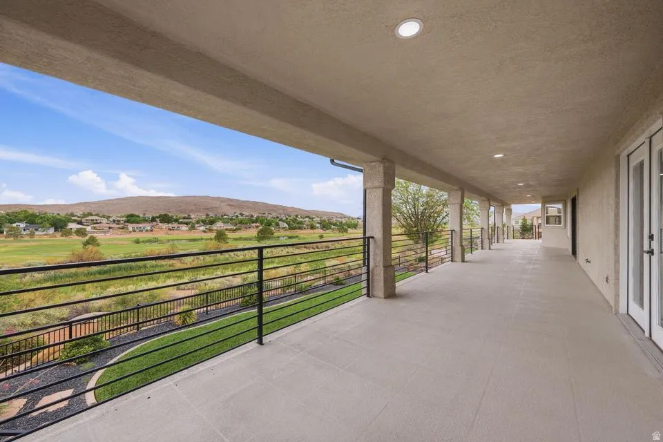 Spacious covered patio with concrete flooring, recessed lighting, and stucco columns