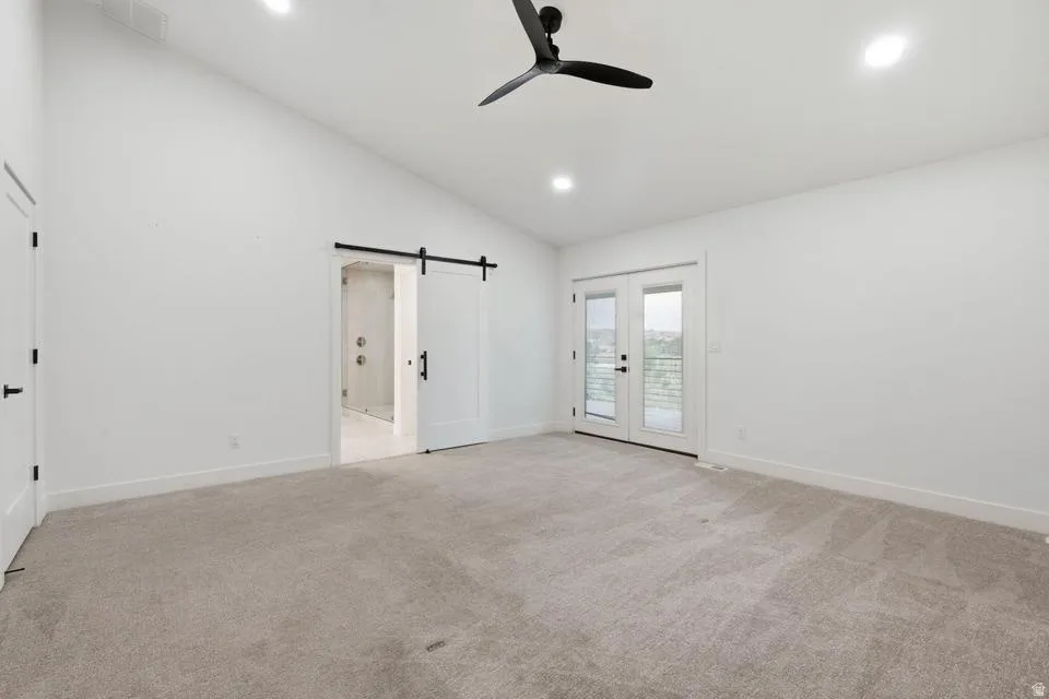 Vaulted ceiling bedroom with light-toned carpet flooring and recessed lighting