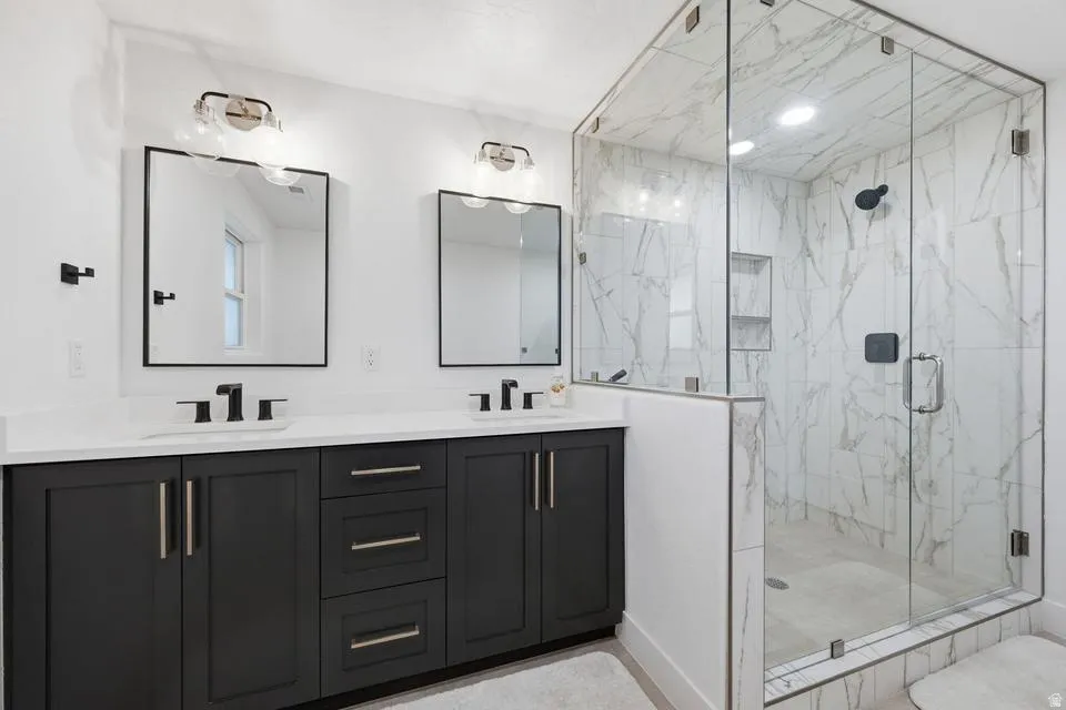 Modern bathroom featuring a dual vanity with dark cabinetry and white countertops