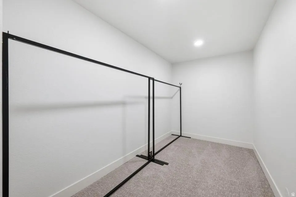 Carpeted room with white painted walls and a flush-mounted ceiling light fixture