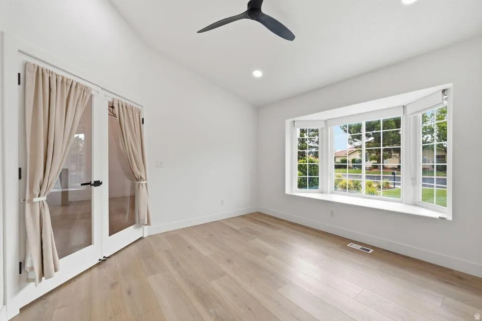 Room featuring light wood-finish flooring, a contemporary ceiling fan, recessed lighting, and a bay window with a broad sill