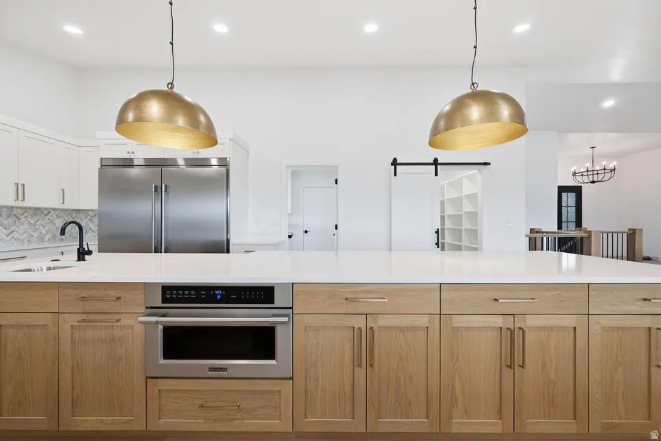 Kitchen island featuring natural wood cabinetry and a built-in microwave drawer