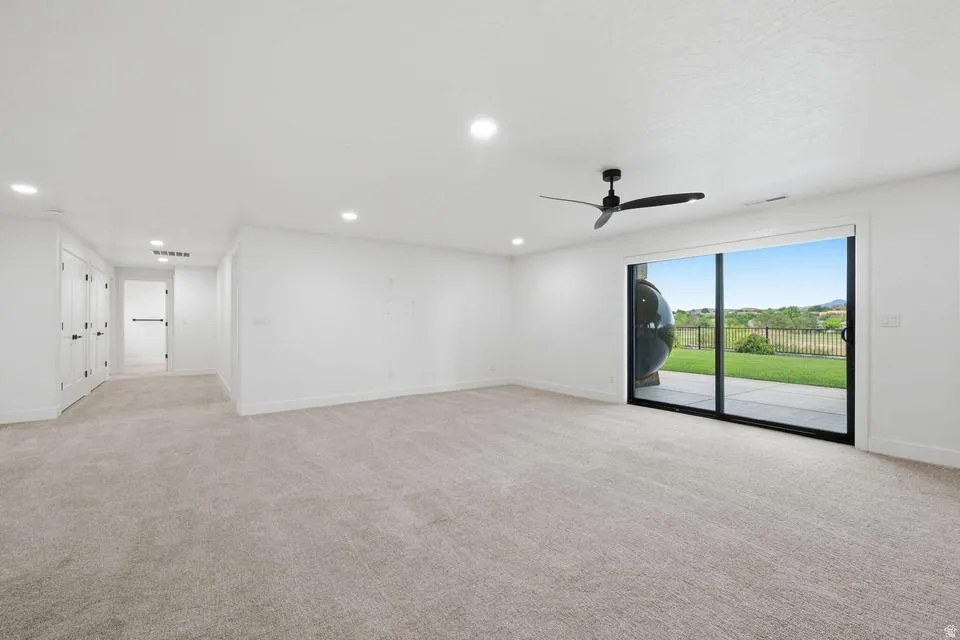 Spacious room with light gray carpet and white walls