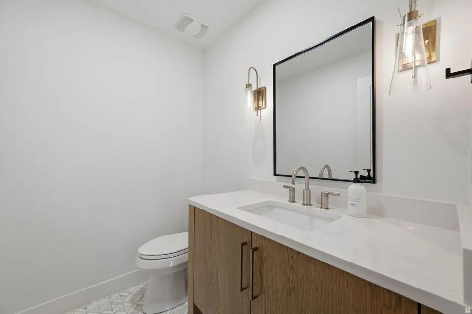 White vanity with wood-finish cabinetry and a light-toned countertop