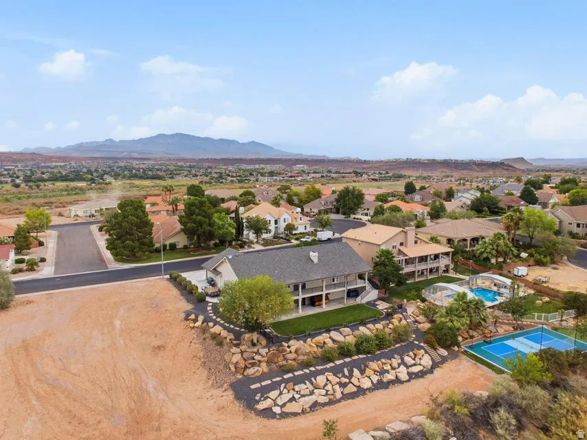 Expansive property featuring a multi-level deck, a swimming pool with an enclosure, and a dedicated tennis court