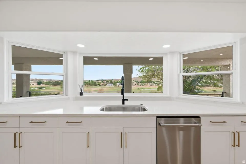 Kitchen sink area featuring a stainless steel undermount sink, a matte black faucet, and a stainless steel dishwasher