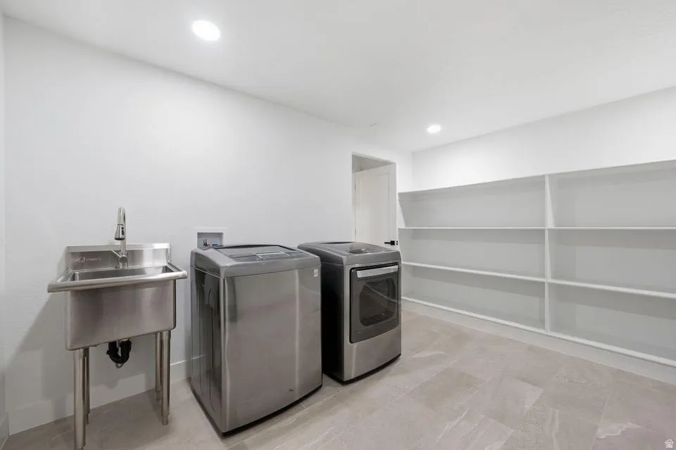 Utility room featuring integrated shelving, a stainless steel utility sink, and tile flooring