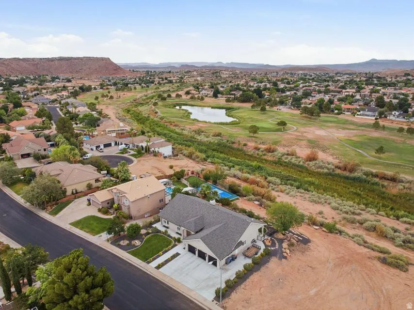 Expansive property featuring a multi-car garage, concrete driveway, and mature landscaping